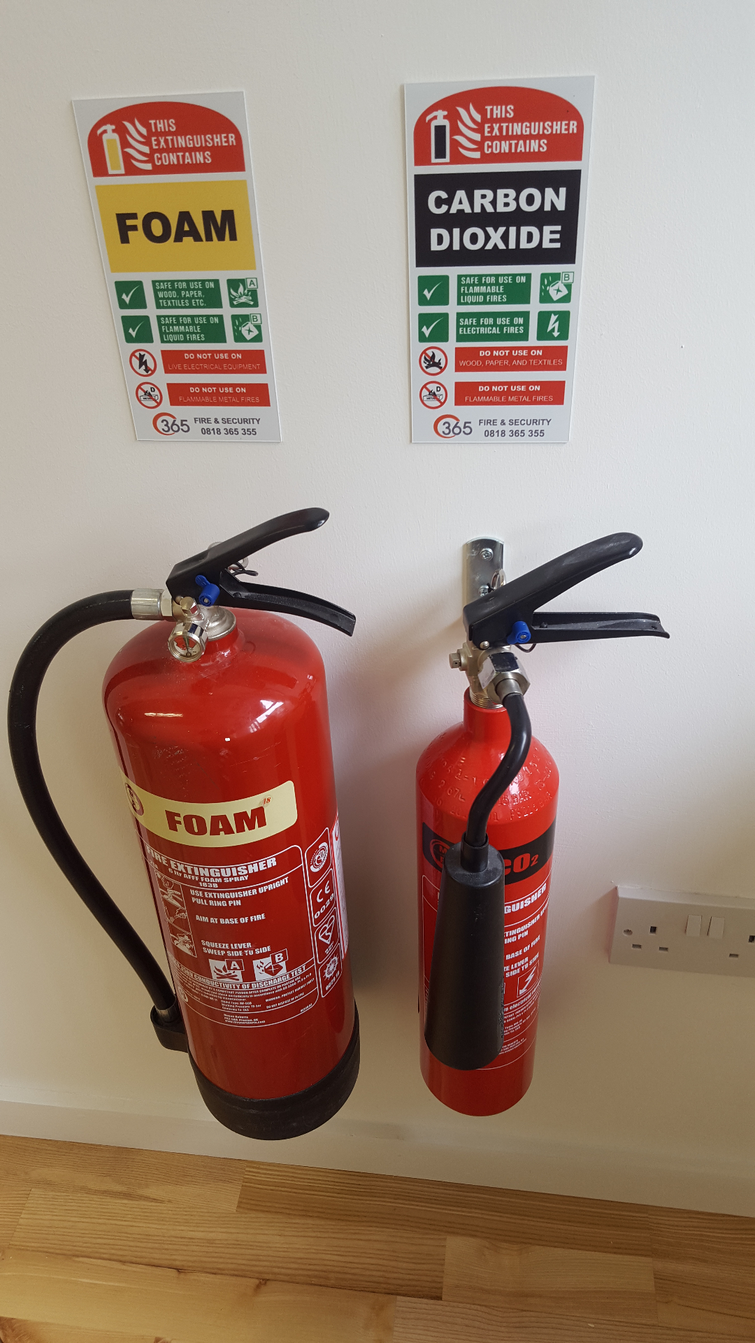 Foam and CO2 fire extinguishers mounted with safety signage